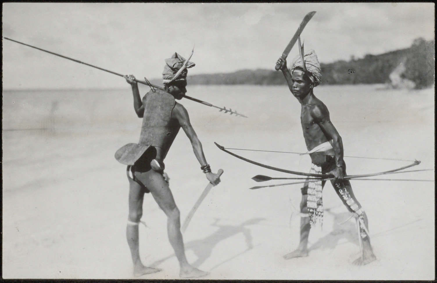 Demonstratie van mannen met een speer met weerhaken, een pijl en boog en kapmessen, Tanimbar -eiland, 1924-1932. International Archiv für Ethnographie. Voorheen Collectie Tillema. (RV-A440-tt-186-206A)