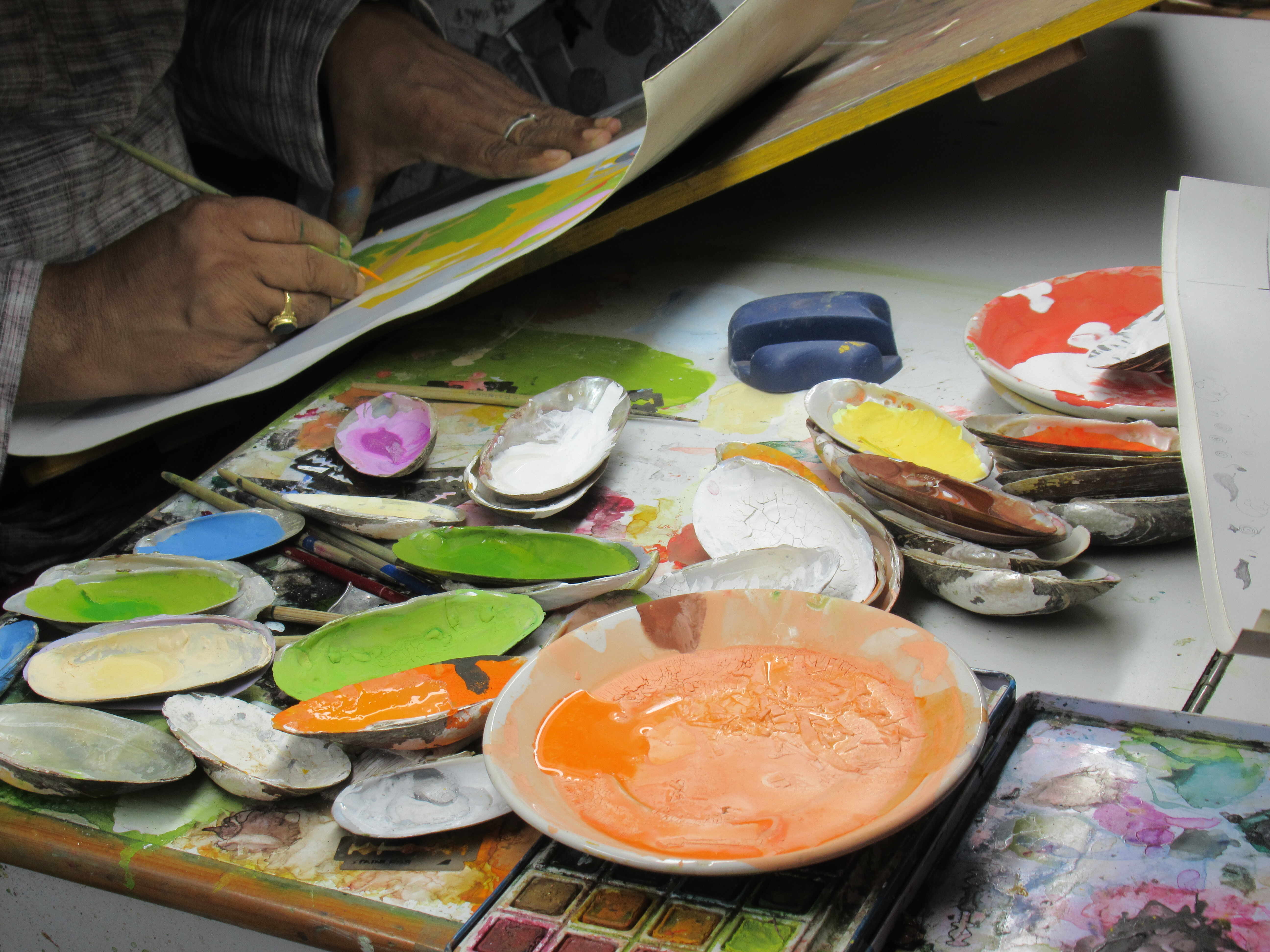 Vijay Sharma's schildersmateriaal, privé studio, Chamba (Himachal Pradesh). De schilder Padma Shri Vijay Sharma aan het werk. (© Amélie Couvrat Desvergnes, oktober 2022)