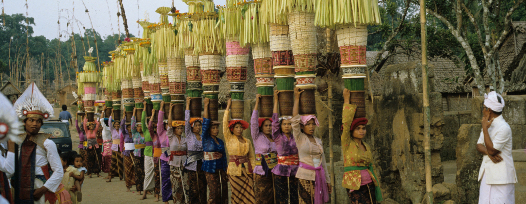 Een groep vrouwen uit dezelfde banjar (wijk) in Penglipuran (een dorp in centraal Bali), allen gekleed in een gekleurde kebaya en gebatikte kain, brengt familieoffers naar de tempel waar op die dag de stichtingsdag van de tempel wordt gevierd, 1 november 1982. (7358-39) © Francine Brinkgreve