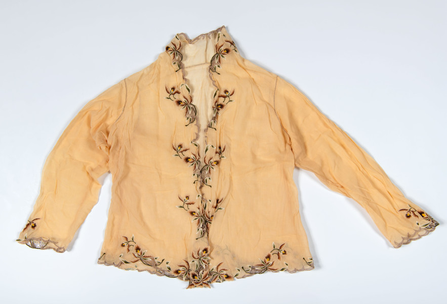 Deze twee kebaya’s zijn van dezelfde snit; kort, strak om het lijf gedragen, met opvallende naden rondom de arminzet en gekleurd borduurwerk. Dit borduurwerk wordt machinaal op de stof gestikt en de rest stof wordt weggeknipt. Dit wordt nog steeds zo gedaan op de Kebaya Nyonya. (RV-6225-2 en 7292-3) 