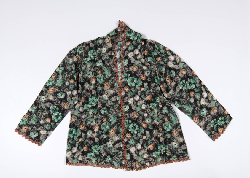De laatste, of misschien jongste, kebaya is van een geprinte stof, in een wat losser vallende model. Vergelijkbaar met wat Han Tek Nio op twee foto’s draagt (7292-428 en 7292-101). De rand is gedecoreerd met herhalende ellipsen dat doet denken aan het batikmotief kawung. Deze zijn net als bij de eerder omschreven kebaya’s geborduurd op de stof en de rest stof is weggeknipt. (7292-4)
