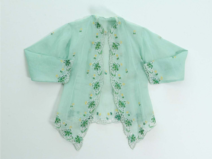 Kebaya Nyonya, een lichtgroene kebaya waarbij de voorkant in een punt uitloopt, Singapore, voor 1993. Met groen en geel borduurwerk (lelies). (TM-5528-17)